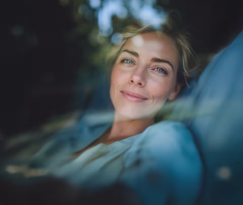 Zufriedene Patientin mit Reflektionen von Blättern in einer Fensterscheibe